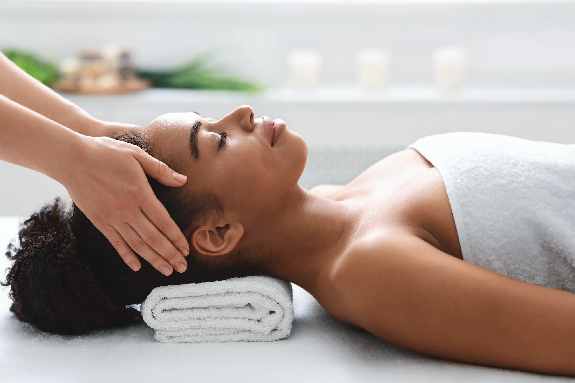 young-black-woman-getting-head-massage-from-massage-therapist.jpg